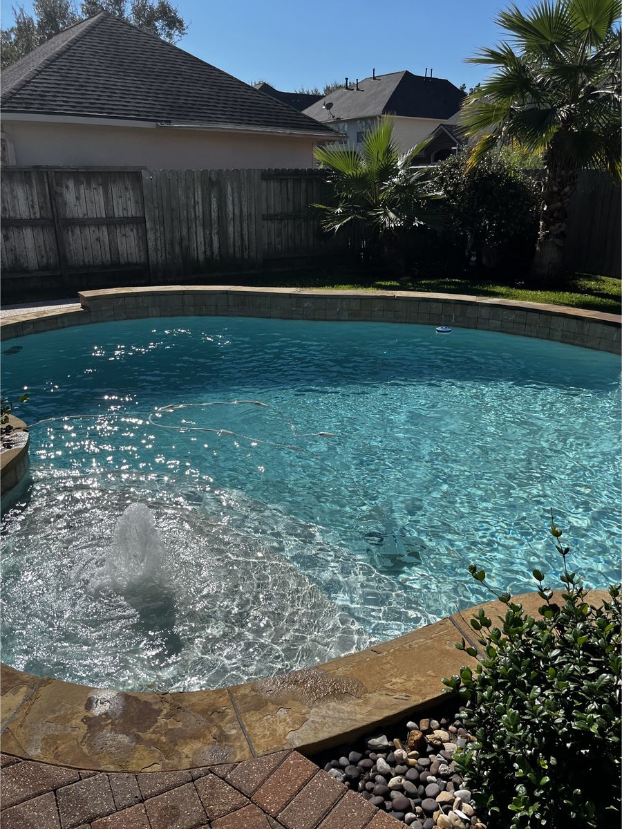 In-ground pool and raised stone spa with crystal-clear water after a weekly cleaning