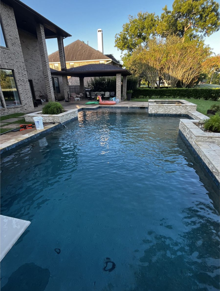 Sparkling pool water beside a covered patio after a Clean Pool Squad service visit